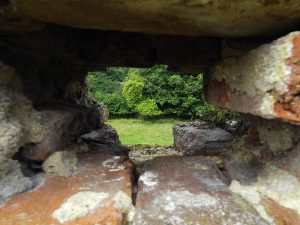 View through the sole remaining musket loop-hole in the western perimeter wall of Basing House overlooking Slaughter Close: Siege of Basing House 1642 to 1645 during the English Civil War