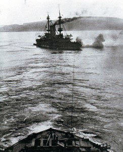 HMS Albion, pre-Dreadnought British battleship, aground in the Dardanelles during the bombardment of the Turkish land defences and being towed off by HMS Canopus